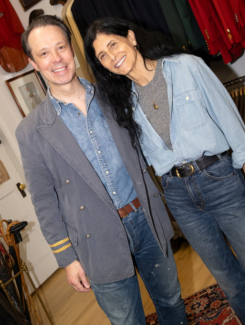 Two smiling individuals wearing denim outfits in a colorful background.